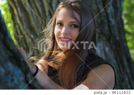 young woman resting on tree at the park in sunshine young woman resting on tree at the park in sunshine 96112652