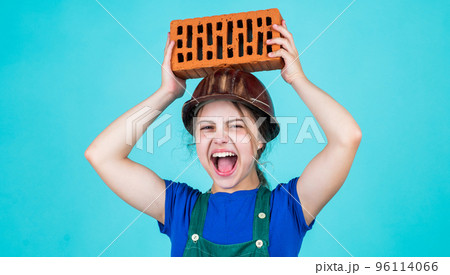 kid wear protective helmet. protect head on construction site. teen girl hold brick. little builder with brick. child is engineer architect. building her future house. happy childhood kid wear protective helmet. protect head on construction site. teen girl hold brick. little builder with brick. child is engineer architect. building her future house. happy childhood 96114066