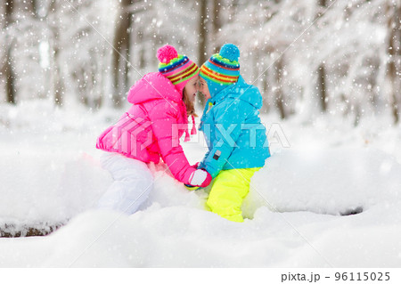 Kids playing in snow. Children play outdoors in winter snowfall. 96115025