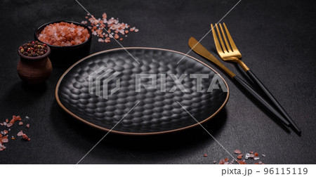 Empty black plate over dark stone background with free space 96115119