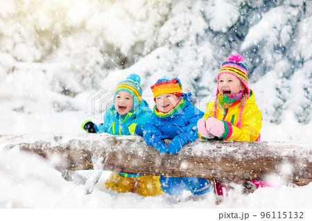 Kids playing in snow. Children play outdoors in winter snowfall. Kids playing in snow. Children play outdoors in winter snowfall. 96115132