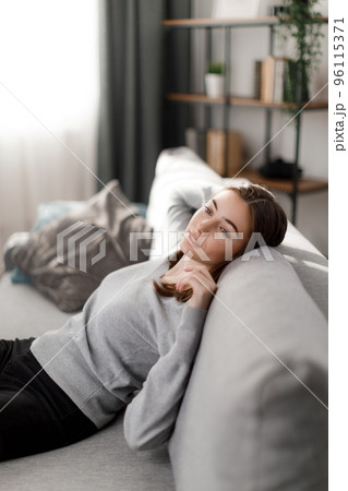Woman relaxing on couch Woman relaxing on couch 96115371