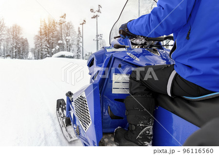 Close-up big modern snow mobile scooter atv vehicle forest road against sunrise sunny sky on cold snowy winter day. Snowmobile rental sport adventure trip service. Arctic nordic snow sledge transport Close-up big modern snow mobile scooter atv vehicle forest road against sunrise sunny sky on cold snowy winter day. Snowmobile rental sport adventure trip service. Arctic nordic snow sledge transport 96116560