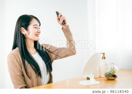 ヘアケアで髪の毛に基礎化粧品・ミスト・スプレーを使う女性 96118340