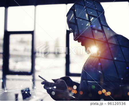 Businessman works with his smartphone in office. double exposure Businessman works with his smartphone in office. double exposure 96120536