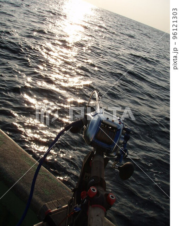 早朝のぎらつく強い日差しを受ける沖釣り用の竿とリール。モノトーンな雰囲気になるように逆光撮影。 96121303