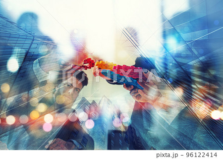 Working group of businessmen find the agreement by holding a piece of gear in hand. concept of teamwork and business partnership. double exposure 96122414