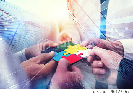 Business people join puzzle pieces in office. Concept of teamwork and partnership. double exposure with light effects Business people join puzzle pieces in office. Concept of teamwork and partnership. double exposure with light effects 96122467