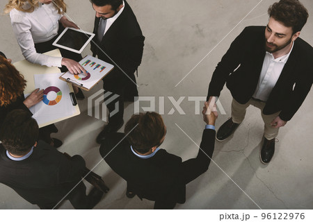 Handshaking business person in office. concept of teamwork and partnership Handshaking business person in office. concept of teamwork and partnership 96122976