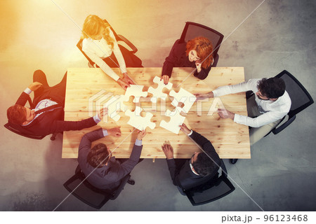 Teamwork of partners. Concept of integration and startup with puzzle pieces Teamwork of partners. Concept of integration and startup with puzzle pieces 96123468