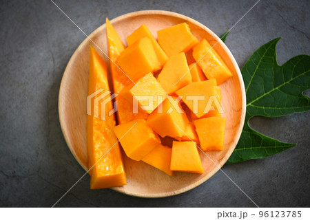 papaya fruits on dark backgroud, fresh ripe papaya slice on plate tropical fruit with leaf leaves from papaya tree papaya fruits on dark backgroud, fresh ripe papaya slice on plate tropical fruit with leaf leaves from papaya tree 96123785