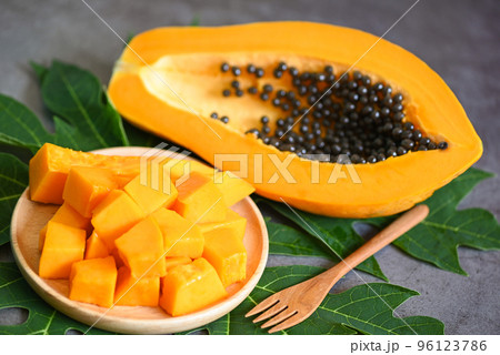 papaya fruits on dark backgroud, fresh ripe papaya slice cut in half tropical fruit with papaya seed and leaf leaves from papaya tree 96123786
