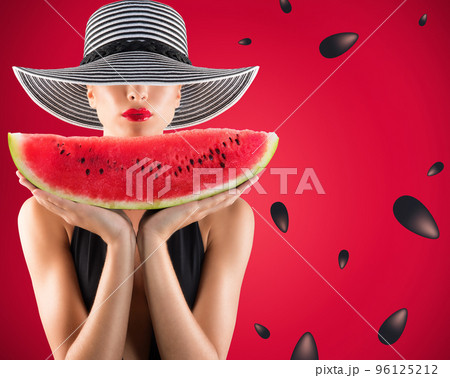 Girl in swimsuit with watermelon in hand and red background with seeds 96125212