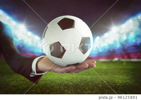 Sport bets. Soccer ball on the hand of a businessman with stadium background Sport bets. Soccer ball on the hand of a businessman with stadium background 96125891