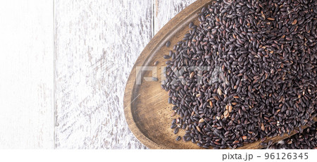Wooden plate with black rice on old wooden background. Close up Wooden plate with black rice on old wooden background. Close up 96126345