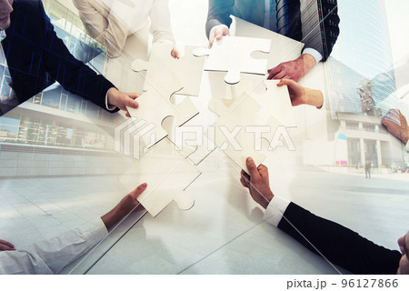 Teamwork of partners. Concept of integration and startup with puzzle pieces. double exposure 96127866
