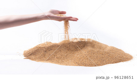 Hand releasing dropping sand. Fine Sand flowing pouring through fingers against white background. Summer beach holiday vacation and time passing concept. Isolated high speed shutter 96128651