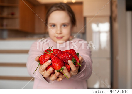 Organic strawberry in hands of young girl 96129610