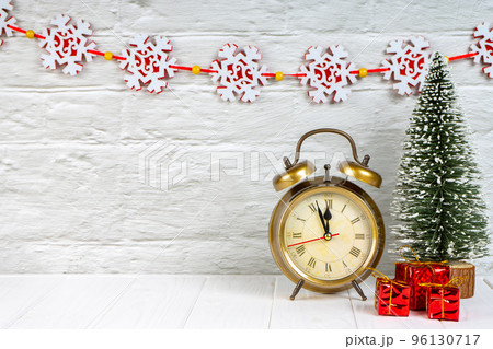 Decorative christmas tree, gift boxes and alarm clock on white wooden background. 96130717