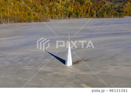 Abstract aerial view of church tower with cross and shadow, flooded by copper mining residuals and mud Abstract aerial view of church tower with cross and shadow, flooded by copper mining residuals and mud 96131381