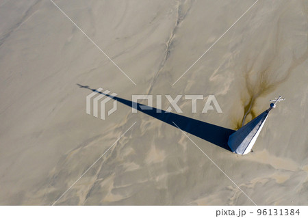 Aerial view of a church tower with cross, buried under mud and mining residuals 96131384