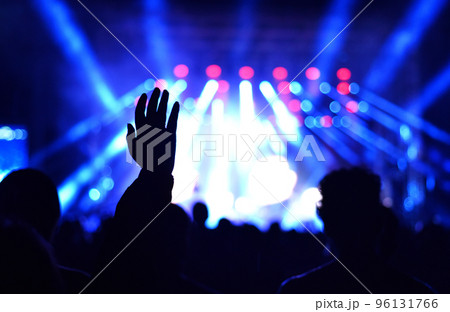 Silhouette of concert crowd in front of bright stage lights 96131766