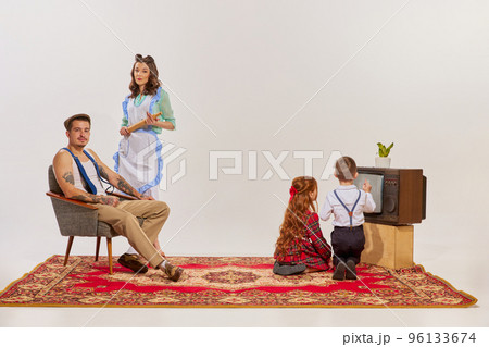 Portrait of young family watching TV isolated over grey background. Kids watching cartoons. 96133674