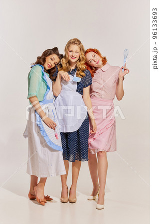 Portrait of three stylish women posing iver grey background. Desperate housewives remake Portrait of three stylish women posing iver grey background. Desperate housewives remake 96133693