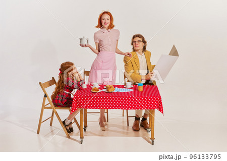 Portrait of beautiful young family having breakfast together isolated on grey background. Movie remake Portrait of beautiful young family having breakfast together isolated on grey background. Movie remake 96133795