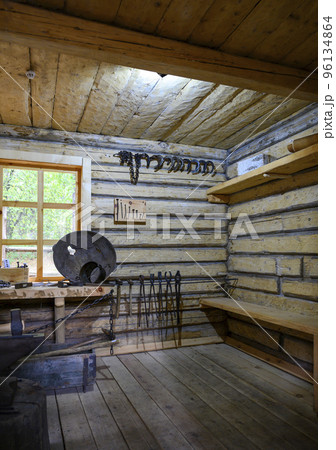 Fragment of a medieval blacksmith's workshop in a wooden hut with tools Fragment of a medieval blacksmith's workshop in a wooden hut with tools 96134864