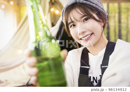 お酒で乾杯をする若い女性　家キャン　グランピングカフェ 96134912