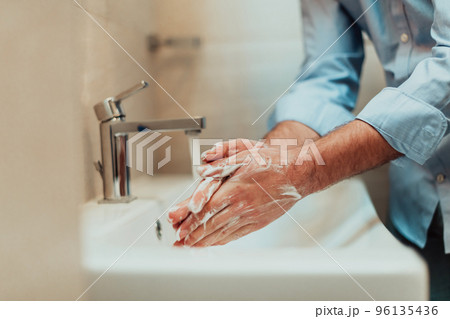 Man using soap and washing hands under the water tap. Hygiene concept hand closeup detail. Man using soap and washing hands under the water tap. Hygiene concept hand closeup detail. 96135436
