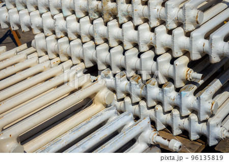 Old cast iron batteries or heating radiators stacked. Scrap metal and recyclables. Background close-up. 96135819