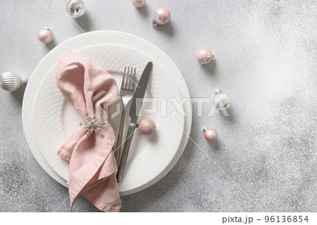 Christmas festive table setting with pink ball and napkin on gray table. 96136854