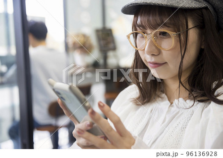 カフェでスマホを見る若い女性 カフェでスマホを見る若い女性 96136928