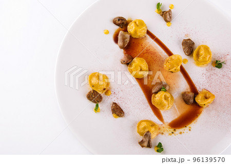 A plate of ravioli with fried kidneys and paprika 96139570