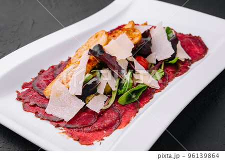 Beef carpaccio with salad and Parmesan on a white plate Beef carpaccio with salad and Parmesan on a white plate 96139864