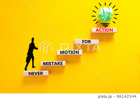 Mistake or action symbol. Concept words Never mistake motion for action on wooden blocks. Businessman icon. Beautiful yellow table yellow background. Business mistake or action concept. Copy space. 96142544
