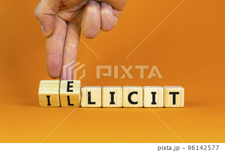 Illicit or elicit symbol. Businessman turns wooden cubes and changes the concept word Illicit to Elicit. Beautiful orange table orange background. Business illicit or elicit concept. Copy space. 96142577