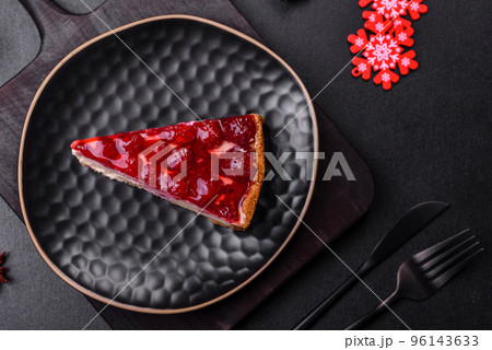 Homemade tasty cheesecake with jelly and raspberry berries on a black plate 96143633