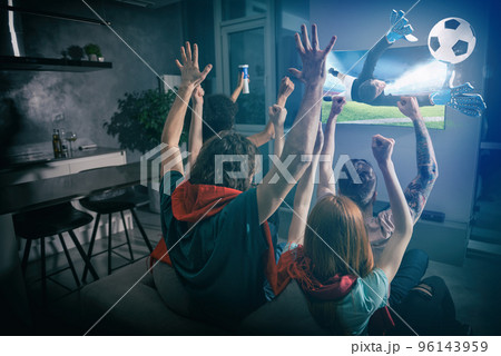 Group of friends watch the game together on television and rejoice Group of friends watch the game together on television and rejoice 96143959