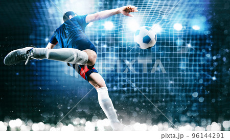Football scene at night match with player kicking the ball with power Football scene at night match with player kicking the ball with power 96144291