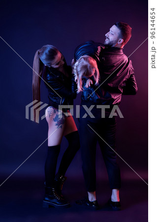 Full size of stylish family mom dad with baby girl having fun on dark background. Family look 96144654