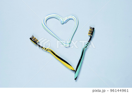 two tooth brushes and a heart shaped brush on a light blue background with copy space in the top right corner two tooth brushes and a heart shaped brush on a light blue background with copy space in the top right corner 96144961