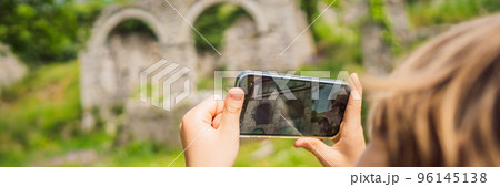 BANNER, LONG FORMAT Augmented reality concept. Hand holding smart phone use AR application to check relevant information about building that was here in ancient times. Augmented reality in history and BANNER, LONG FORMAT Augmented reality concept. Hand holding smart phone use AR application to check relevant information about building that was here in ancient times. Augmented reality in history and 96145138