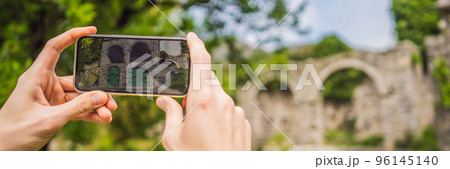 BANNER, LONG FORMAT Augmented reality concept. Hand holding smart phone use AR application to check relevant information about building that was here in ancient times. Augmented reality in history and BANNER, LONG FORMAT Augmented reality concept. Hand holding smart phone use AR application to check relevant information about building that was here in ancient times. Augmented reality in history and 96145140