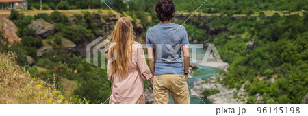 BANNER, LONG FORMAT Couple man and woman tourists on background of purest waters of the turquoise color of the river Moraca flowing among the canyons. Travel around Montenegro concept Portrait of a BANNER, LONG FORMAT Couple man and woman tourists on background of purest waters of the turquoise color of the river Moraca flowing among the canyons. Travel around Montenegro concept Portrait of a 96145198