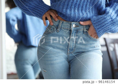 Woman wearing jeans near mirror indoors, closeup Woman wearing jeans near mirror indoors, closeup 96146154