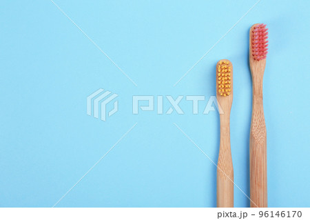 Toothbrushes made of bamboo on light blue background, flat lay. Space for text Toothbrushes made of bamboo on light blue background, flat lay. Space for text 96146170