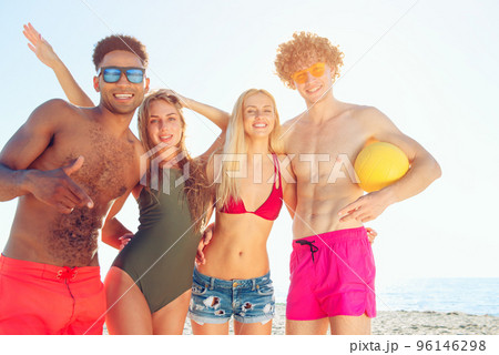Group of friends playing at beach volley at the beach 96146298